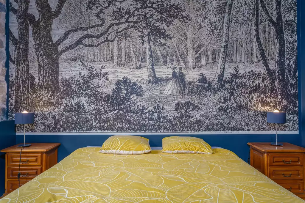 Chambre double du Château de Gorze avec papier peint panoramique forêt et linge de lit jaune