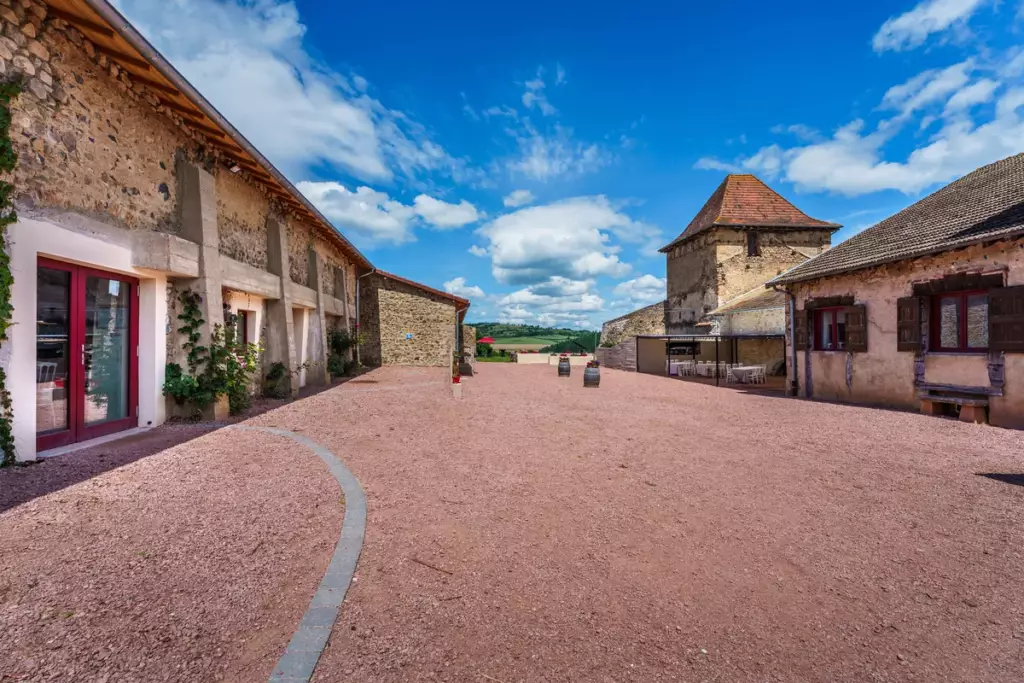 Cour intérieure du Château de Gorze avec tour médiévale, salle de réception et cour en gravier rose