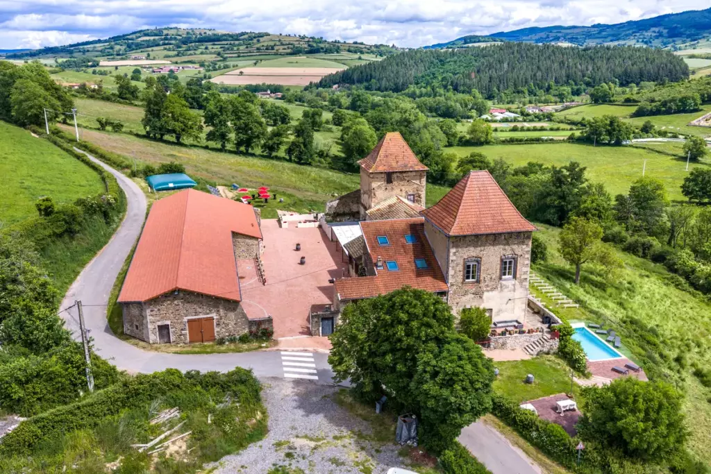 Vue aérienne complète du Château de Gorze – piscine, cour intérieure, tours médiévales et campagne verdoyante