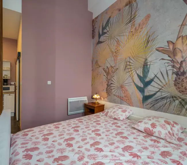 Chambre double du Château de Gorze avec papier peint tropical et linge de lit fleuri rose