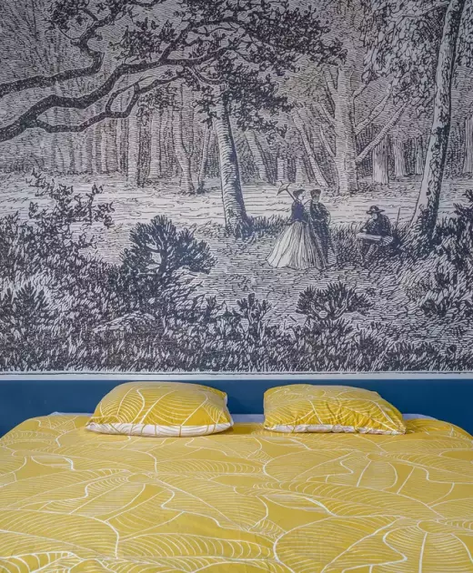 Chambre double du Château de Gorze avec papier peint panoramique forêt et linge de lit jaune