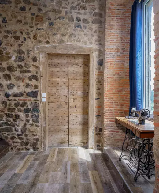 Porte ancienne en bois avec encadrement en pierre dans le gîte du Château de Gorze – décoration authentique